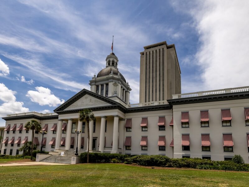 AI-generated illustration of a Florida state courthouse exterior at golden hour, with legal documents on marble steps representing a landmark AI lawsuit filing