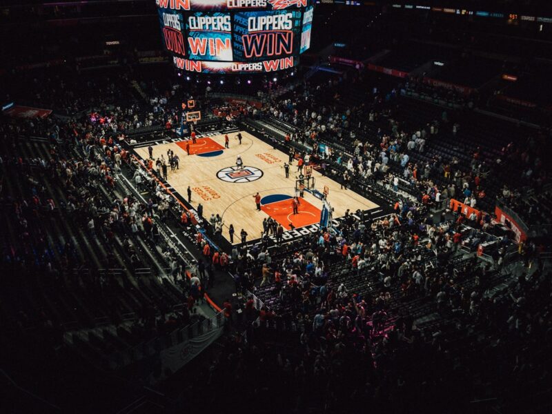 AI-generated illustration of an empty NBA arena at night with dramatic lighting over the hardwood court, symbolizing the offseason and championship anticipation