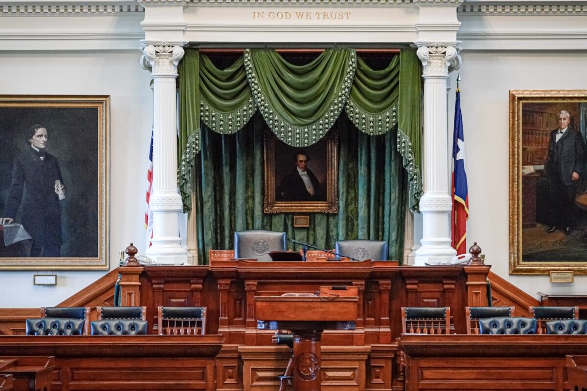 AI-generated illustration of an empty Texas courtroom interior with a judge's bench, wooden gallery seats, and institutional lighting conveying legal solemnity