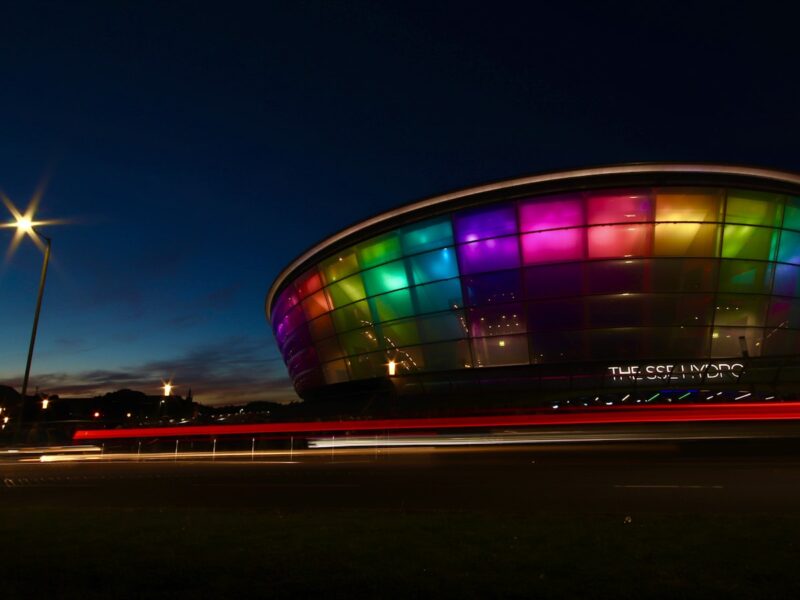 AI-generated illustration of a packed stadium lit with colourful projections during a Commonwealth Games opening ceremony at night