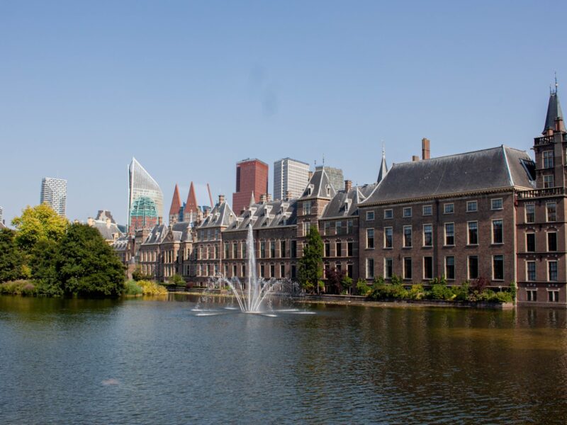 AI-generated illustration of the International Criminal Court building in The Hague on a gray overcast day, empty plaza in the foreground, austere institutional mood