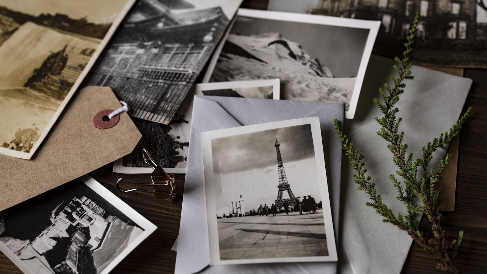 Old family photographs and strips of negatives laid out on a table beside a plain storage box in soft daylight
