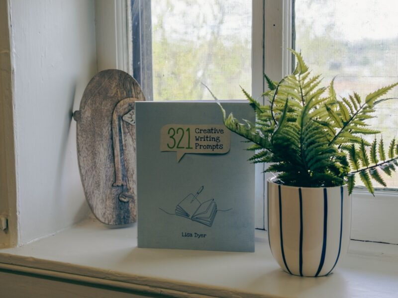An open book resting on a windowsill beside a cup of tea in soft morning light, with the pages out of focus