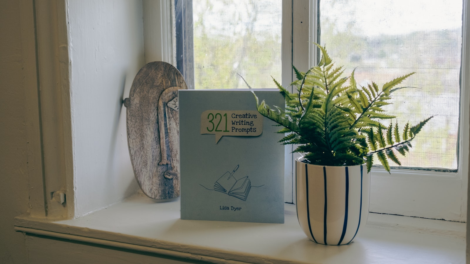 An open book resting on a windowsill beside a cup of tea in soft morning light, with the pages out of focus