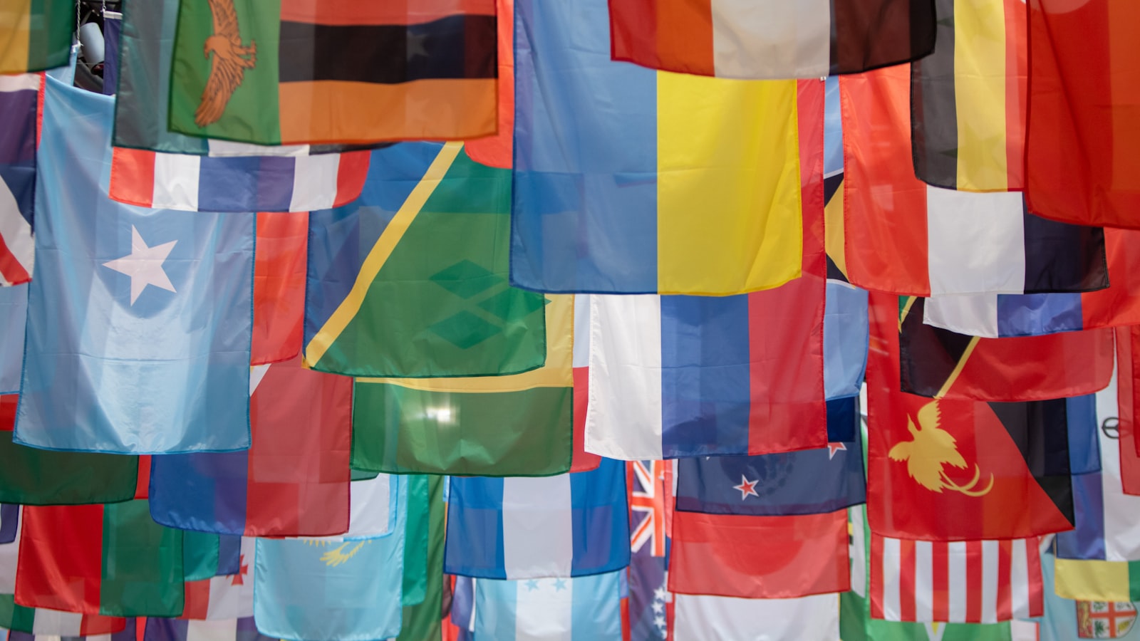 AI-generated illustration of a formal diplomatic negotiation room with national flags, an oval conference table and government documents under warm overhead lighting