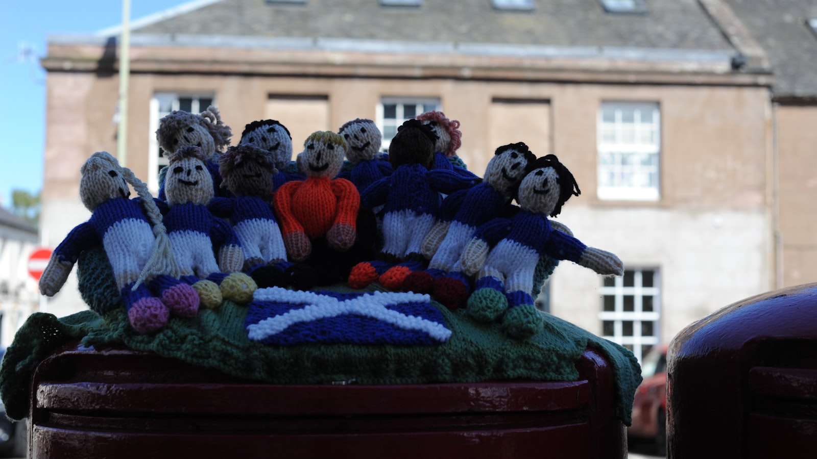 AI-generated illustration of Scottish football supporters celebrating in a floodlit stadium, blue and white scarves raised in the night air