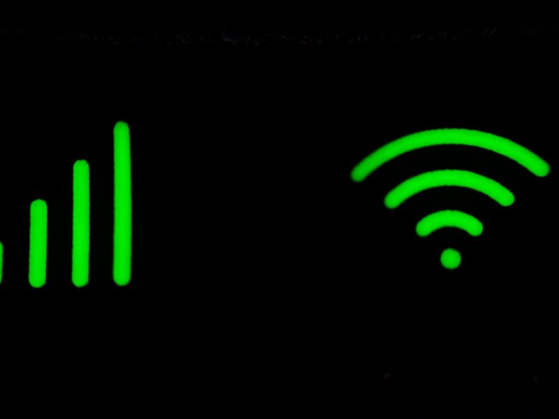 AI-generated illustration of a modern Wi-Fi router with blue LED lights on a home office desk, representing home network security in 2026